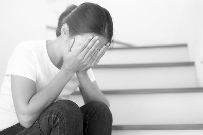 Midsection of woman sitting against wall