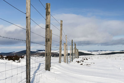 Scenic view of snow covered field against sky