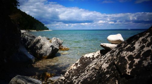 Rock formations by sea against sky