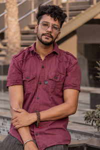 Portrait of young man standing against wall