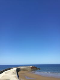 View of beach against clear blue sky