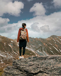 Full length of man standing on rock against sky