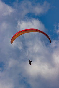 Low angle view of person paragliding against sky