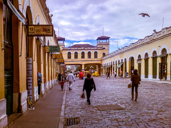 People walking on street amidst buildings in city