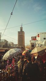 People on street in city against sky