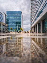 Reflection of buildings in city against sky