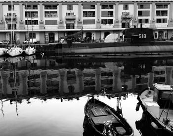 Boats moored in city against sky