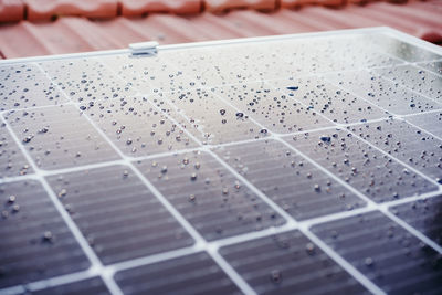 Close up of water drops on solar panel on roof during sunrise.renewable energies and green energy