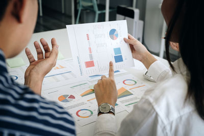 Midsection of business colleagues reading documents