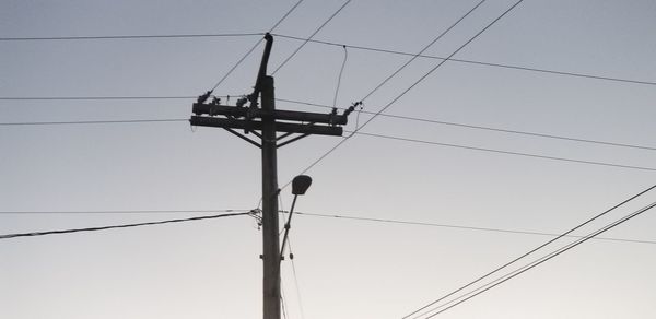 Low angle view of overhead cable car against sky