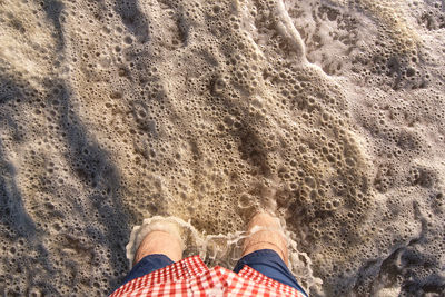 Low section of man standing on rock