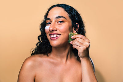 Portrait of young woman against pink background