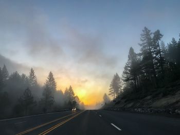 Road amidst trees against sky