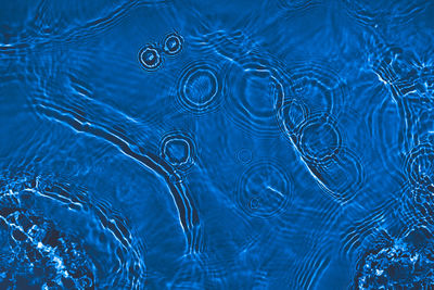 Transparent dark blue colored clear calm water surface texture