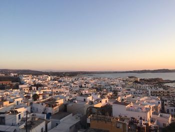 High angle view of townscape by sea against clear sky