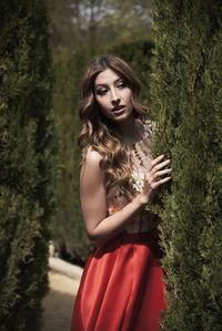 Young woman standing by tree