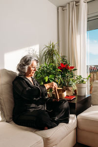 Young woman sitting on sofa at home