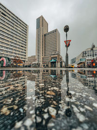 Reflection of buildings on wet road in rainy season