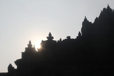 Silhouette temple against clear sky during sunset