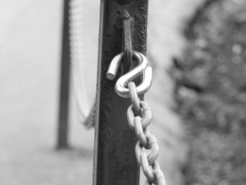 Close-up of chain hanging on metal fence