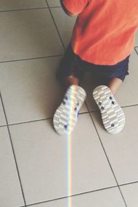 Low section of boy on tiled floor