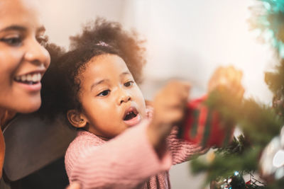 Mother and daughter decorating christmas tree