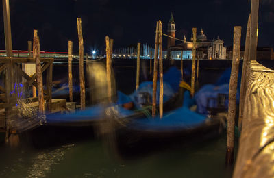 Sailboats moored in canal at night
