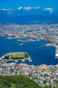 High angle view of townscape by sea against sky