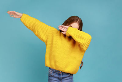Woman standing against yellow blue background
