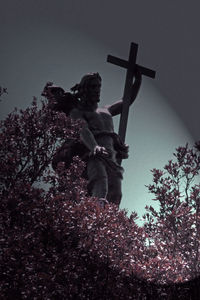 Low angle view of cross on tree against sky