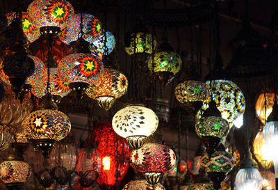 Illuminated lanterns hanging in market stall