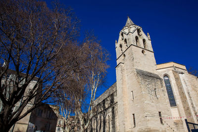 Low angle view of trees and building against sky