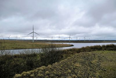 Scenic view of reservoir and field against sky