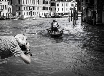 Rear view of man photographing on grand canal