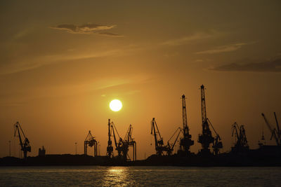 Silhouettes of cranes at the sunset