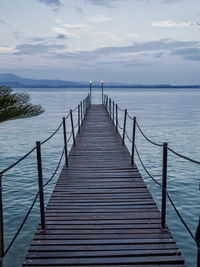 Wooden pier over sea against sky