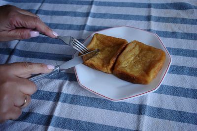 High angle view of hand holding food on table