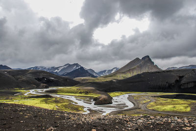Road by mountains against sky