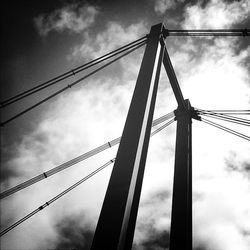 Low angle view of power lines against cloudy sky