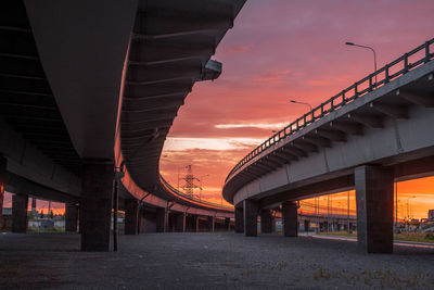 Bridge in city against sky during sunset