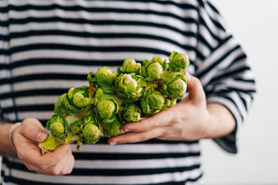 Cropped image of man holding organic brussel sprouts still attached on the stem