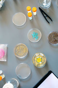 Laboratory instrument set and glitter samples in petri dishes over a lab table background