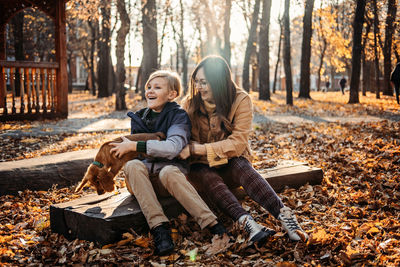 Autumn walks with dog. happy family mother and teen boy son having fun with cute cocker spaniel