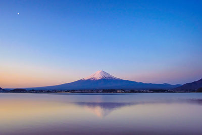 Scenic view of snowcapped mountain against blue sky during sunset