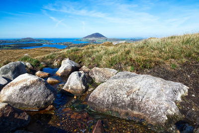 Rocks by sea against sky