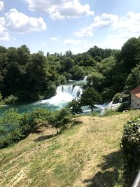 Scenic view of waterfall against sky