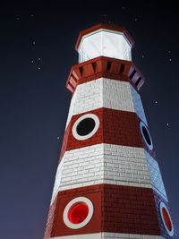 Low angle view of lighthouse against sky at night