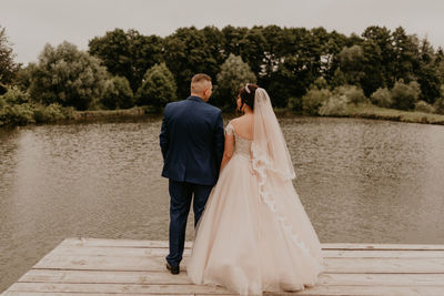 Rear view of woman standing by lake