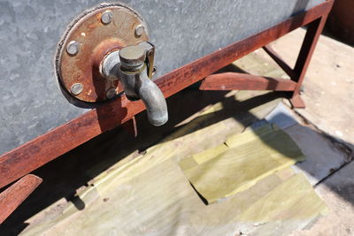 Close up picture of the old faucet of water tank under sunlight