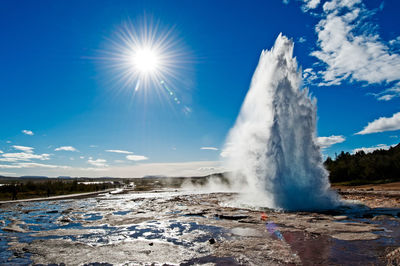 Scenic view of waterfall on landscape against sky